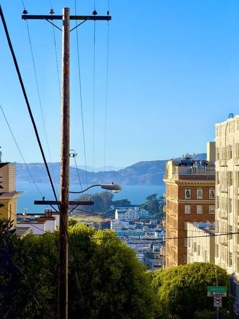 A Pacific Heights street with the bay in the distance